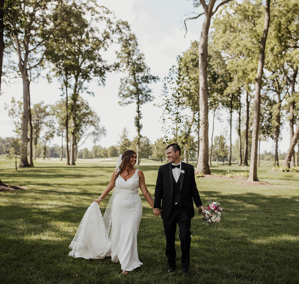 bride and groom walking amongst the trees